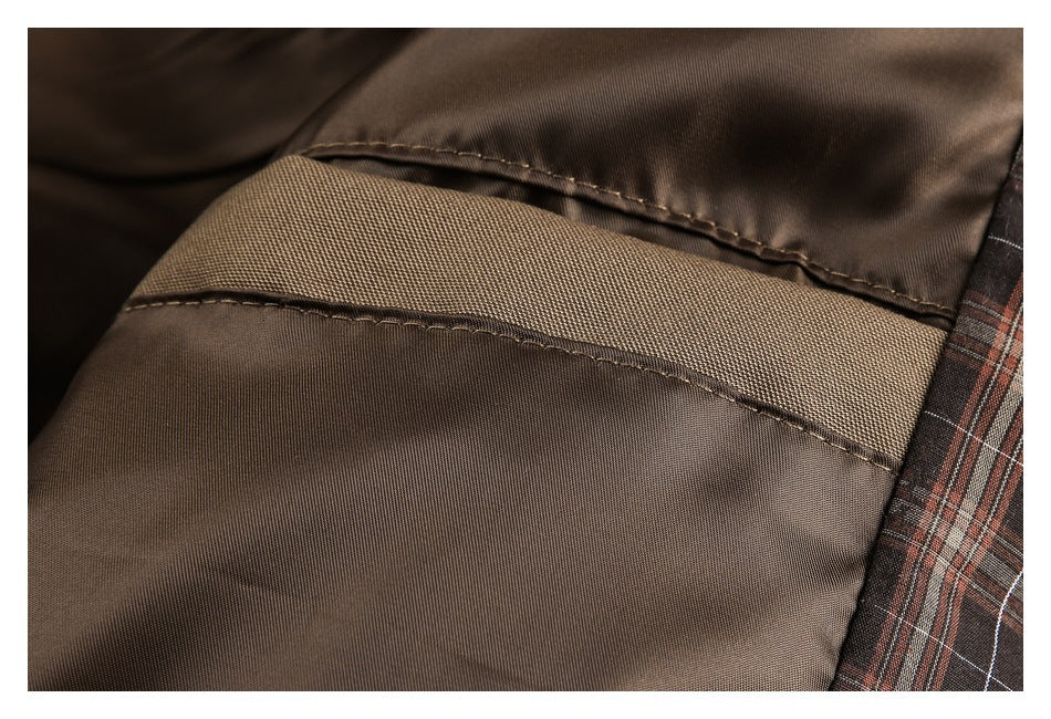 Close-up of stitched seams on brown garment fabric beside a strip of plaid lining.