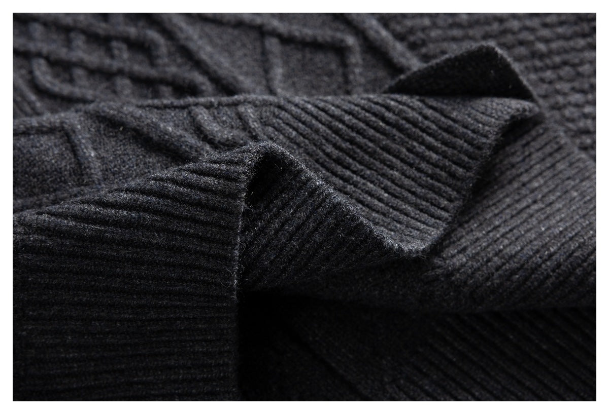 Close-up of a charcoal gray cardigan sleeve with a wide ribbed cuff and cable-knit body.