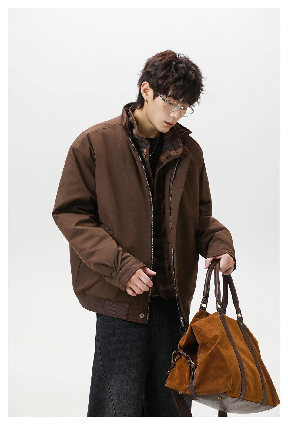 Three-quarter view of a model wearing an open brown jacket with a plaid inner layer.