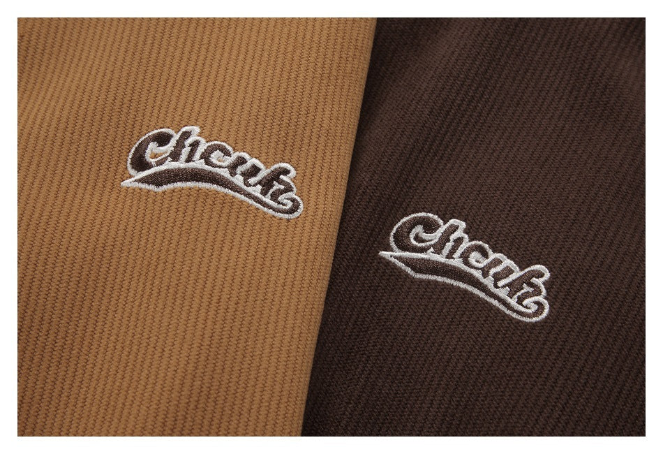 Close-up of embroidered white script logos on tan and dark brown ribbed fabric.