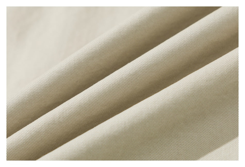 Close-up of beige fabric showing a fine diagonal ribbed texture and soft folds.