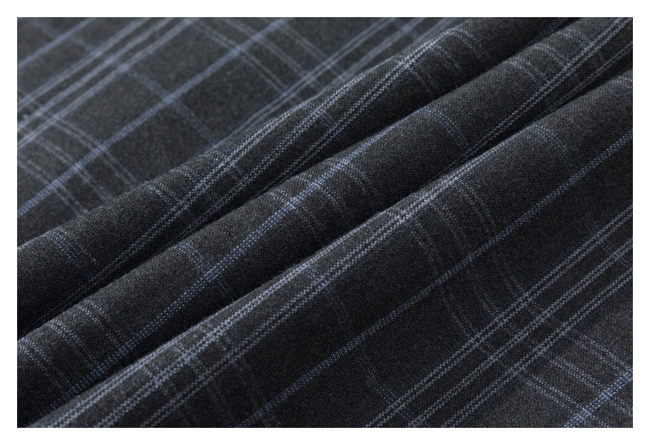 Close-up of dark charcoal fabric with a blue-gray plaid pattern and soft folds.