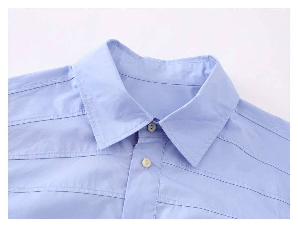 Close-up of a light blue shirt collar, upper placket, buttons, and horizontal chest stitching.