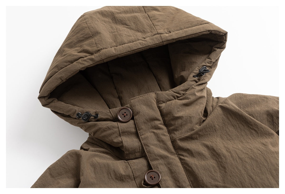 Close-up of a brown jacket's large hood, drawcord toggles, high collar, and button closure.
