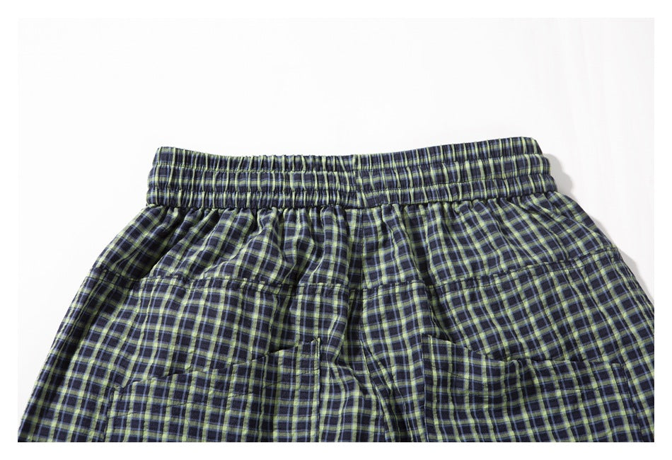 Back view of navy plaid shorts with an elastic waistband and two patch pockets.
