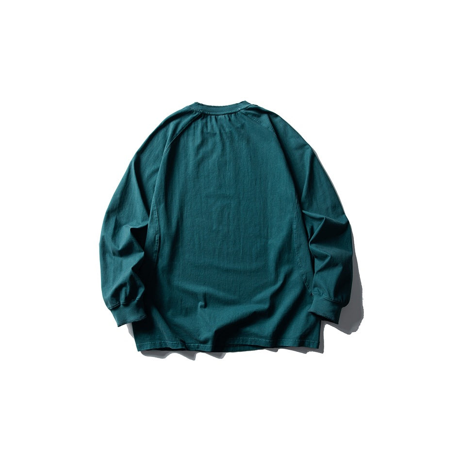 Back view of a deep teal long-sleeve raglan crewneck top with ribbed cuffs and neckline.
