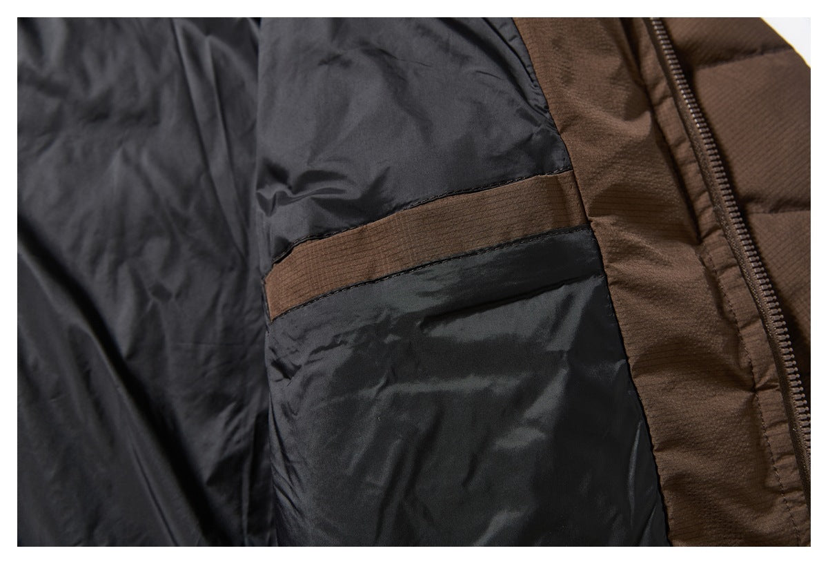 Close-up of a black jacket lining with a brown horizontal fabric panel beside the zipper.
