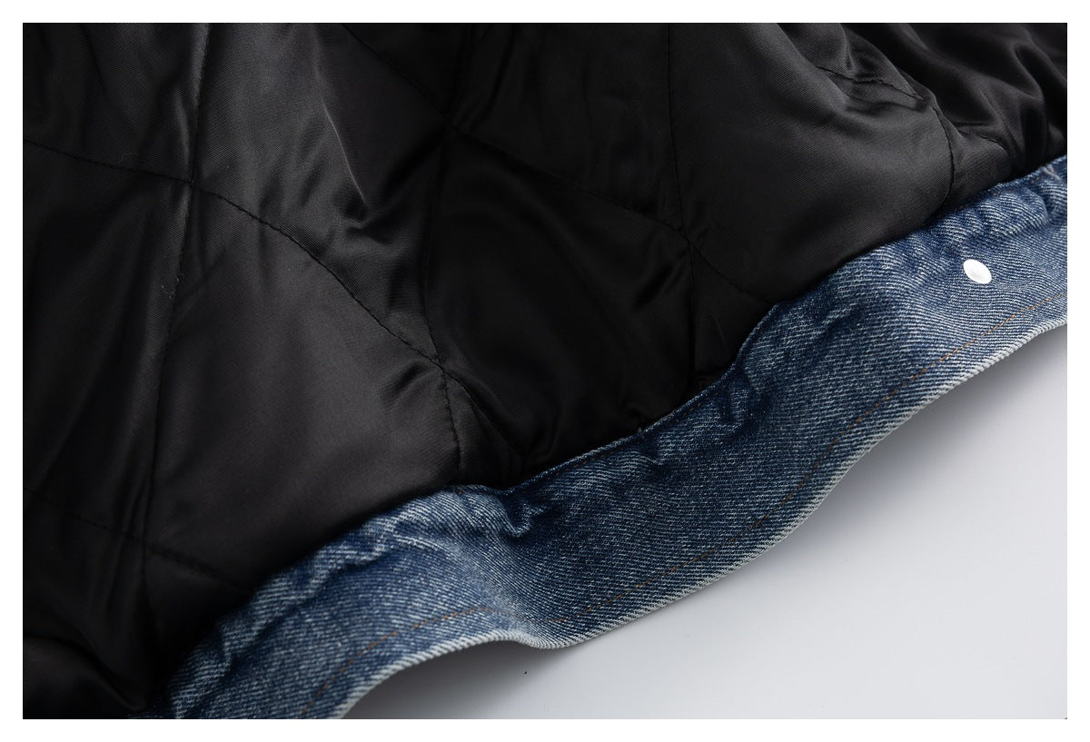 Close-up of black quilted jacket lining beside a blue denim edge with a silver snap.