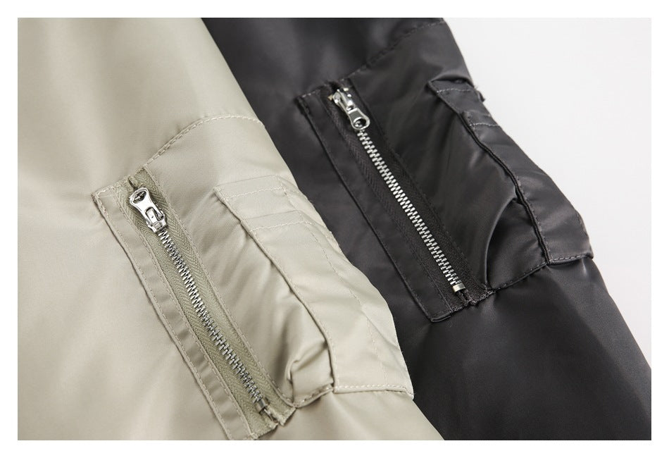 Close-up of beige and black jacket sleeves, each with a zip pocket and flap utility pocket.