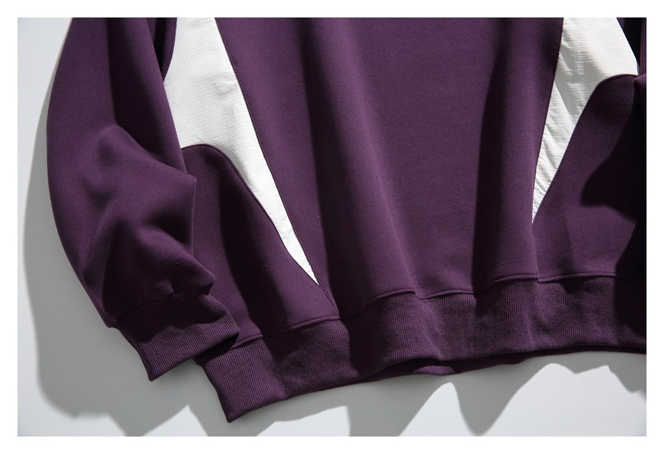 Cropped view of the plum sweatshirt's ribbed hem, sleeve cuffs, and white side inserts.
