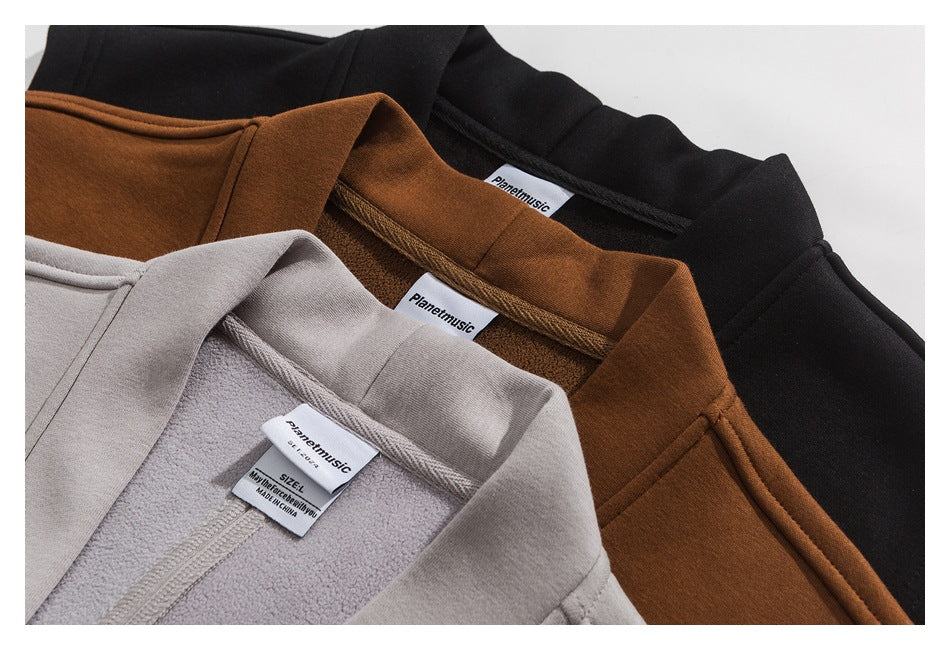 Close-up of black, rust-brown, and light gray coats showing their collars and sewn-in neck labels.
