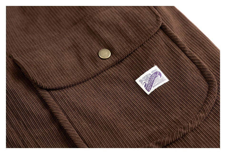 Close-up of a brown corduroy flap pocket with a brass snap and a small sewn label.