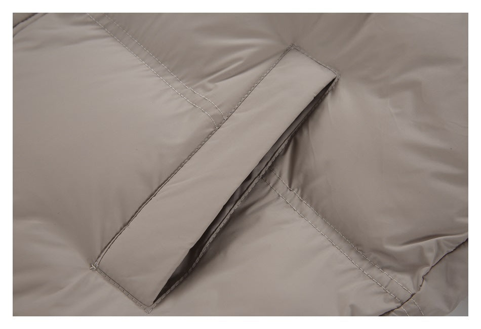 Close-up of a stitched flap pocket on the taupe jacket.