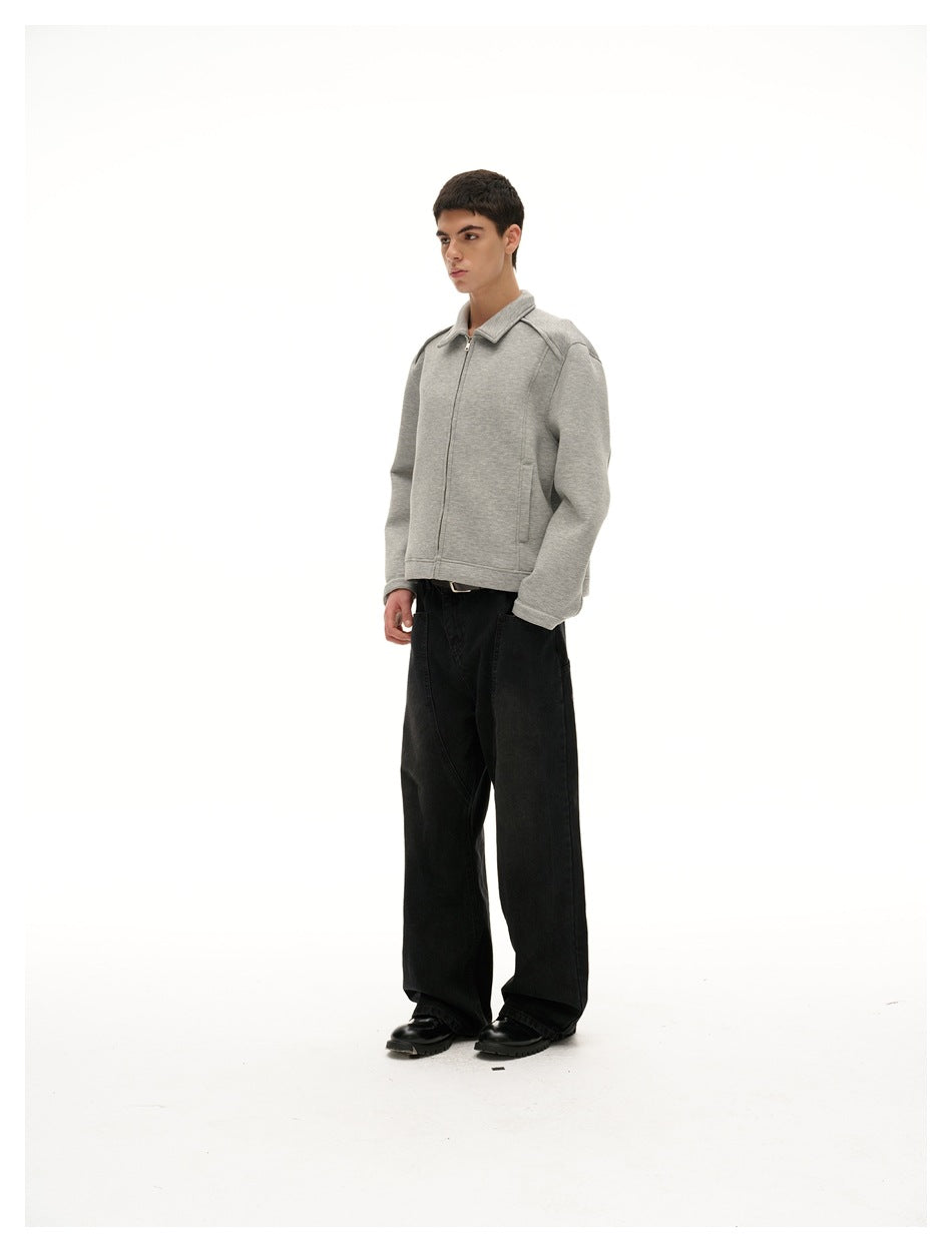 Model in a gray zip-up collared jacket with black wide-leg jeans, three-quarter side view