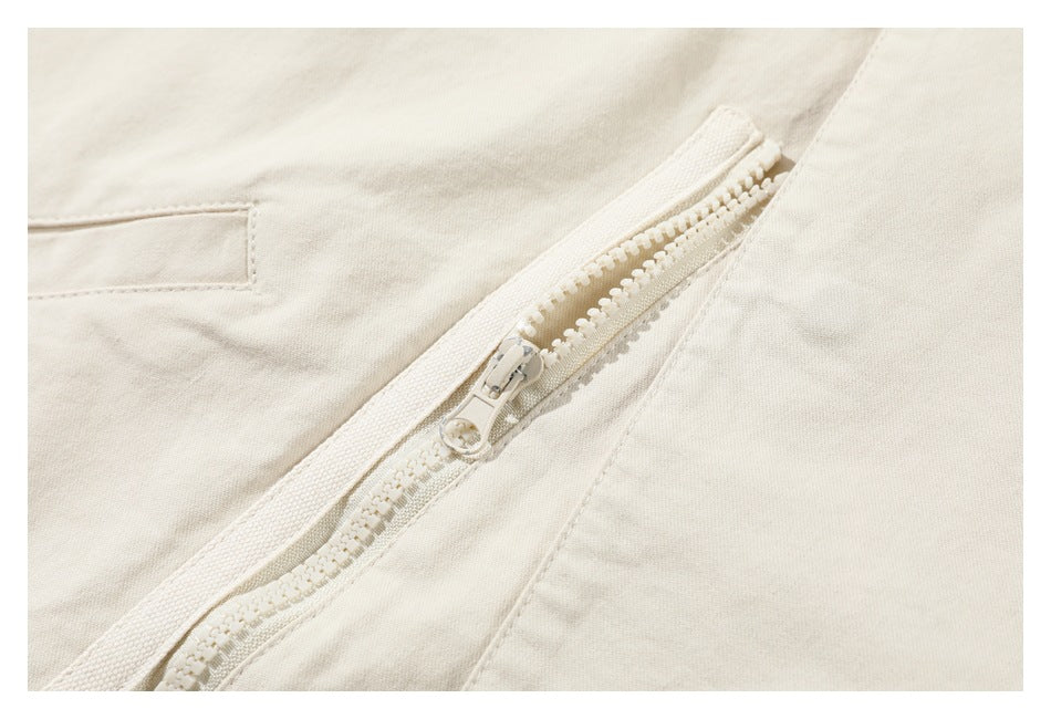 Close-up of an ivory garment with a chunky matching zipper and nearby seam details.