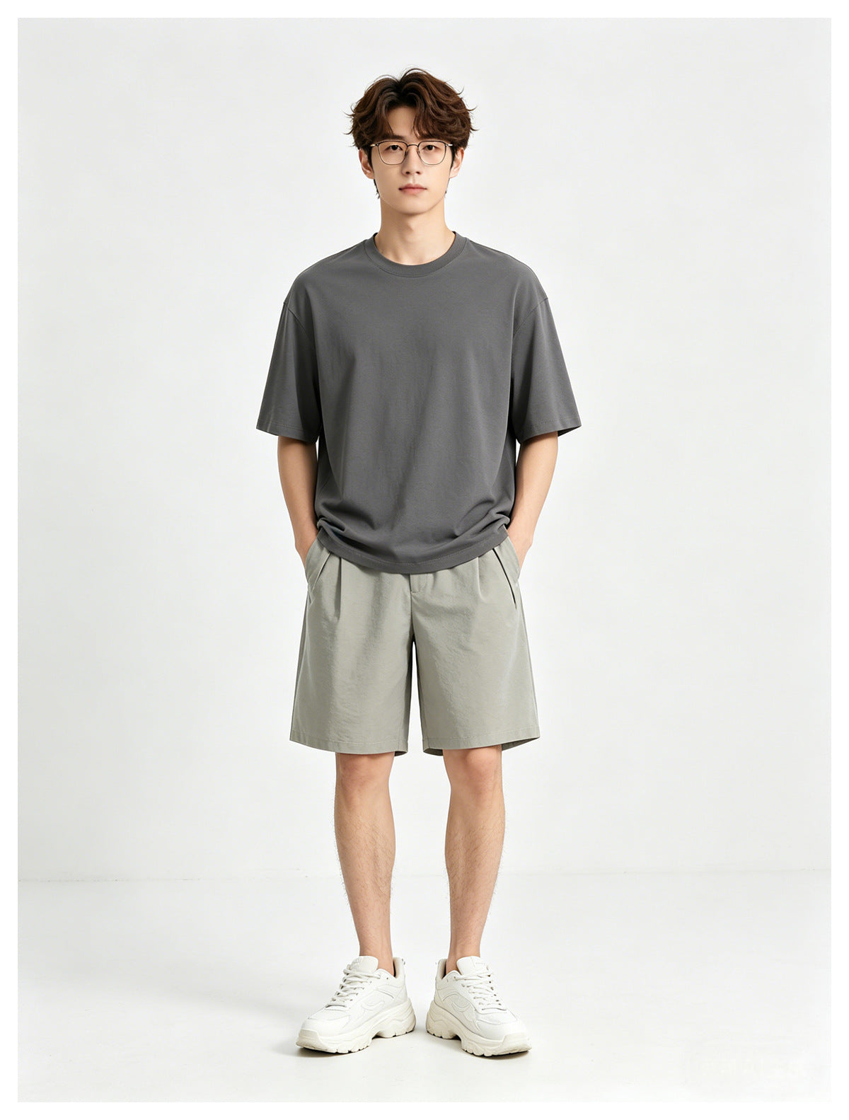 Model wearing a charcoal-gray T-shirt and light gray shorts, front view.