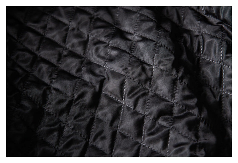Close-up of black quilted garment lining with stitched geometric panels.