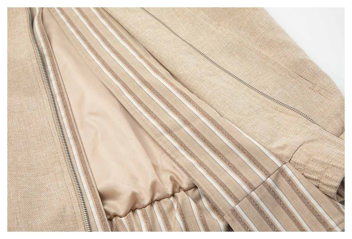 Close-up of the open beige jacket showing its striped patterned inner panel, smooth lining, and zipper.