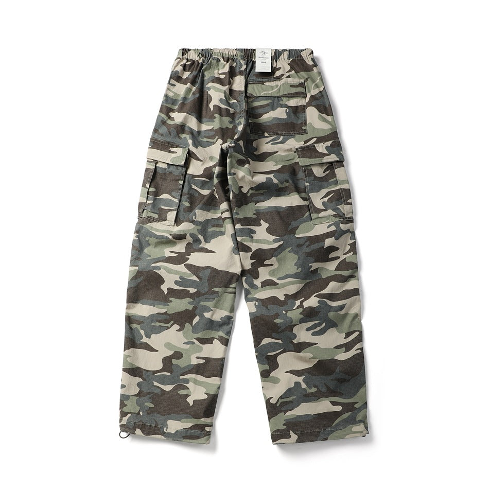 Full back view of loose green, gray and beige camouflage cargo pants with rear and side pockets.