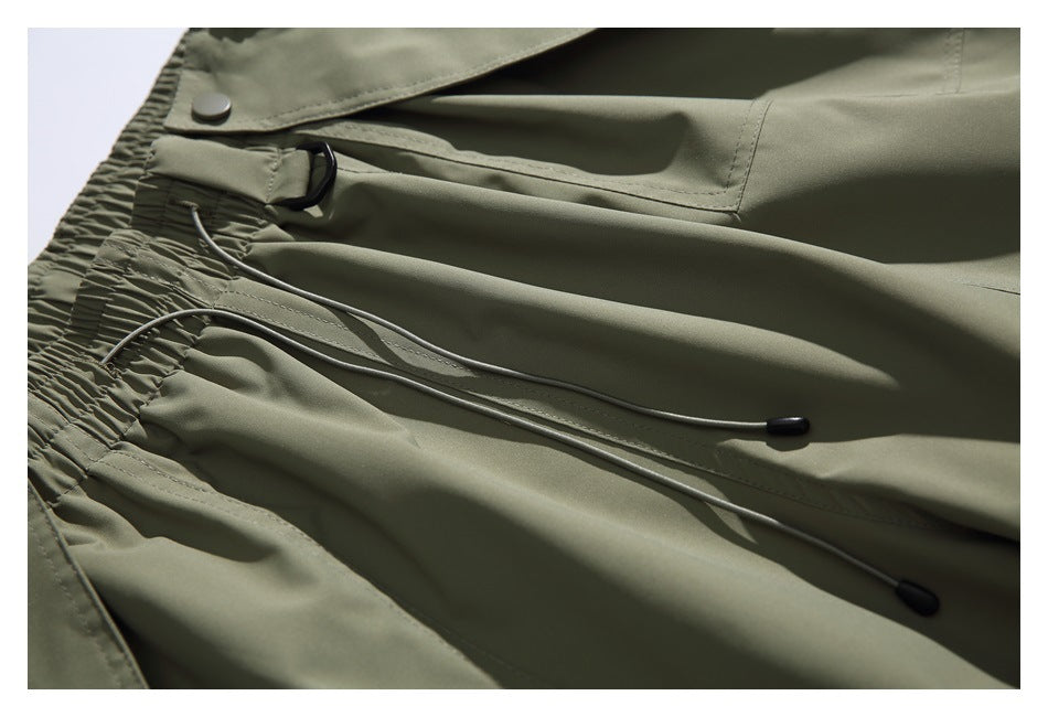 Close-up of the pants' gathered waistband, black loop and two adjustable drawcords with dark end caps.