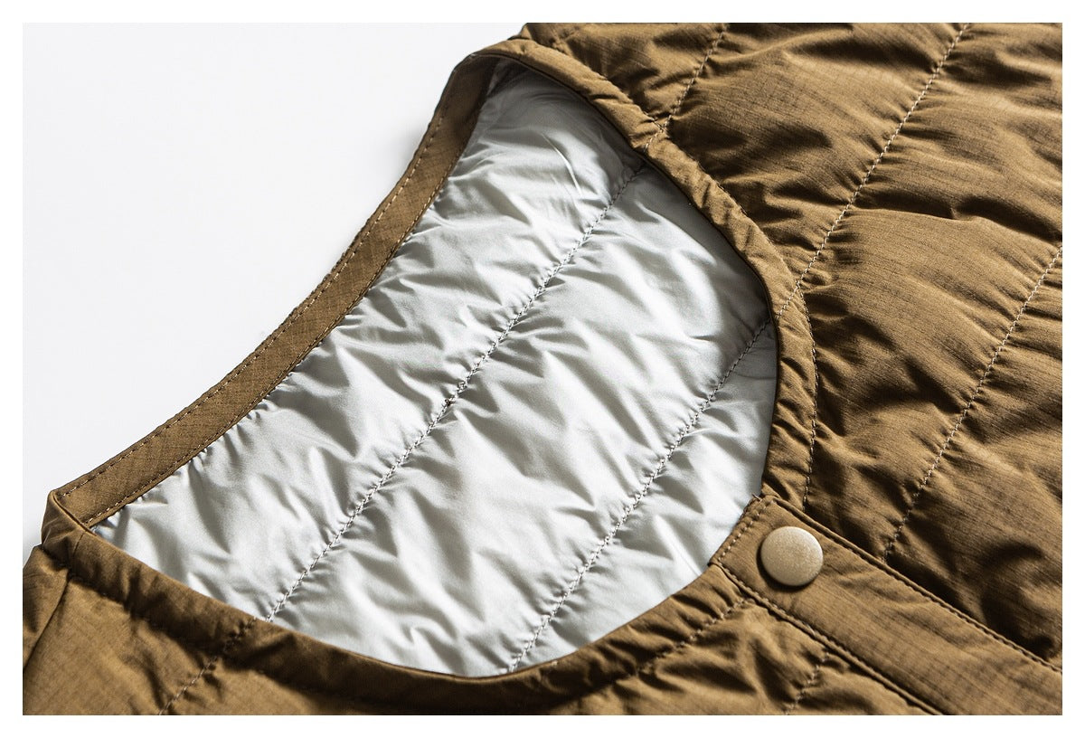 Close-up of a brown quilted jacket opening with pale padded lining and a snap-button tab.