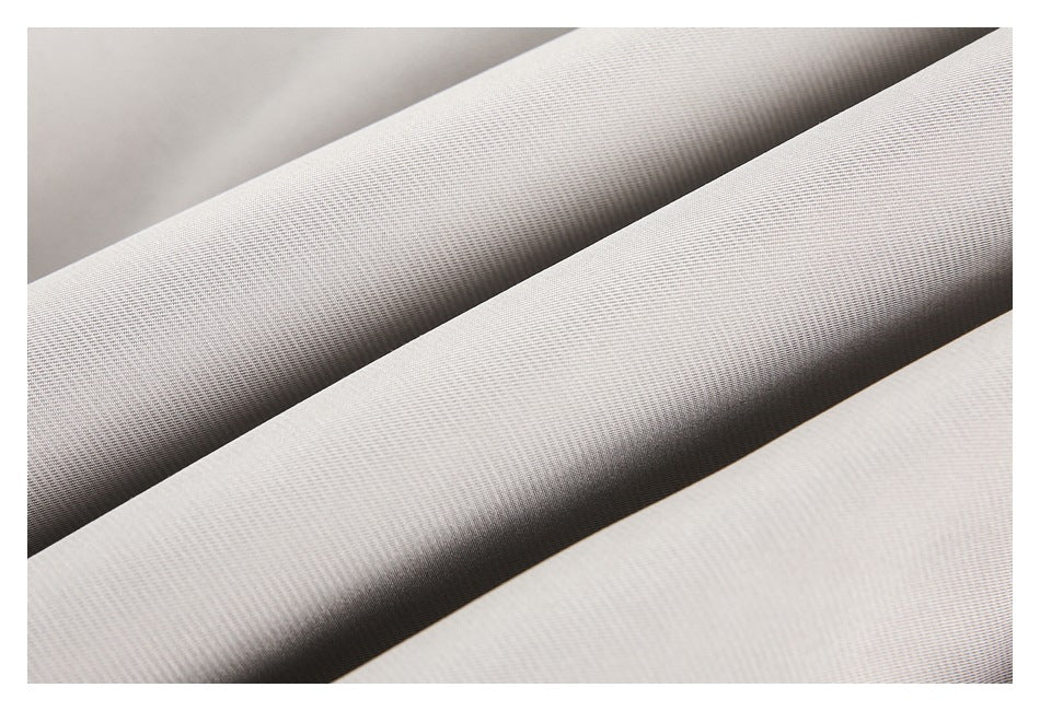 Macro view of the fine diagonal weave and folds of light gray fabric.