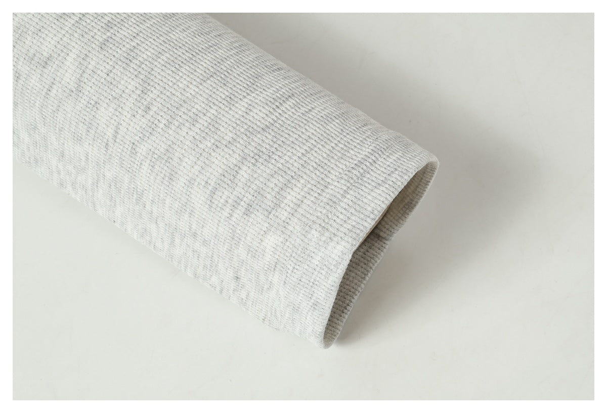 Close-up of a light gray ribbed sleeve ending in a simple open cuff.