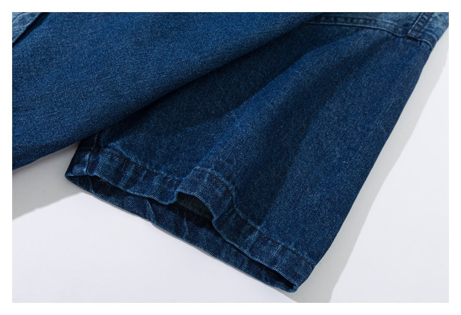 Close-up of the folded cuff and seam on a dark blue denim shirt sleeve.