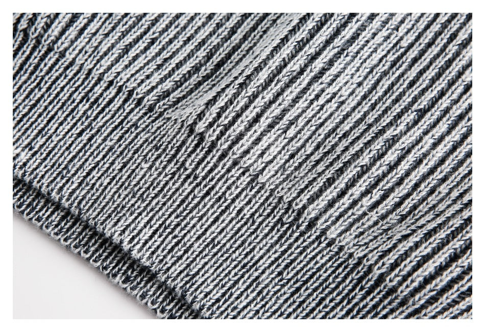 Close-up of black and white marled rib-knit fabric with a diagonal finished edge.