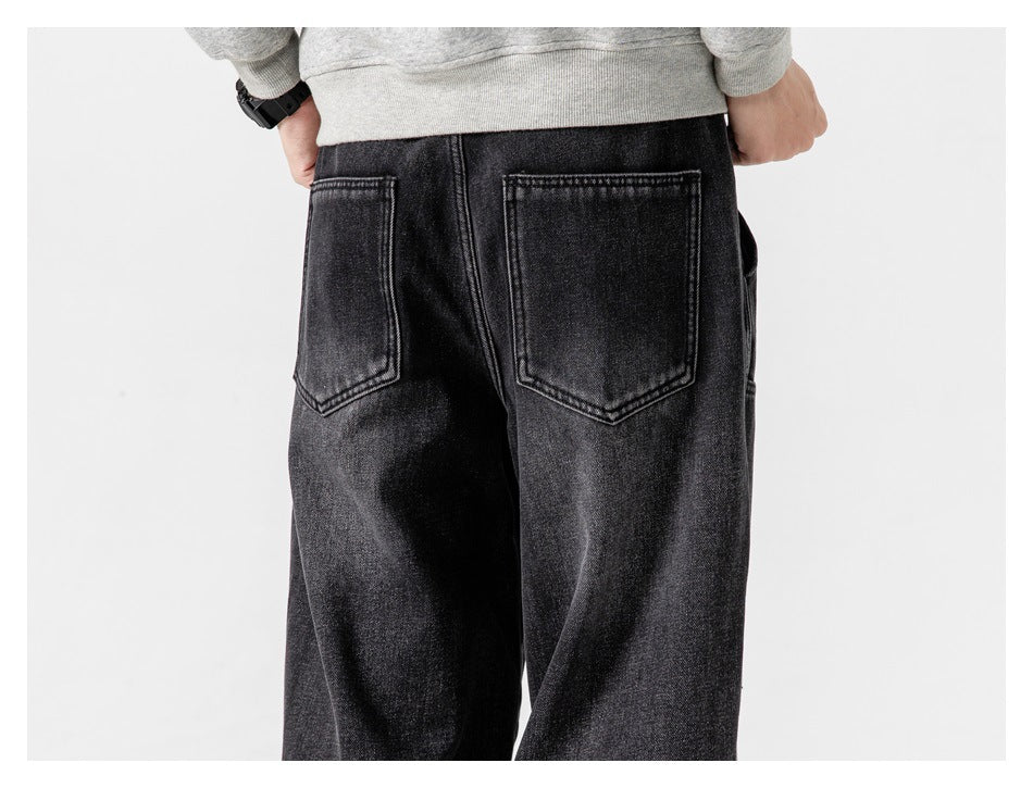 Back view of a person wearing black wide-leg jeans with two back patch pockets.