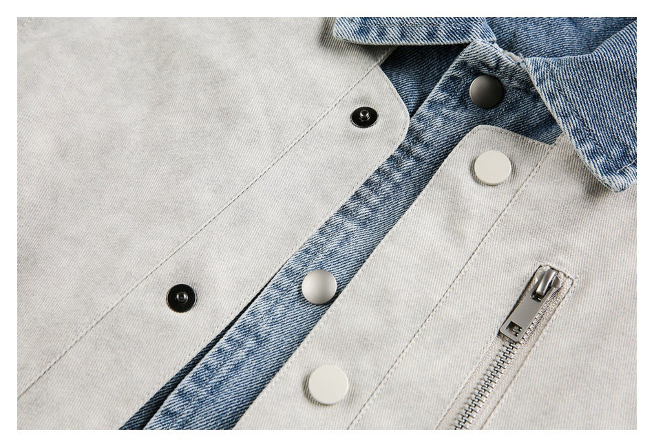 Close-up of a light gray jacket front with blue denim trim, snap buttons, and a silver zip pocket.