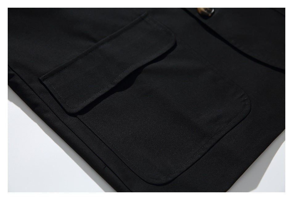 Close-up of a black blazer pocket flap and stitched welt pocket.