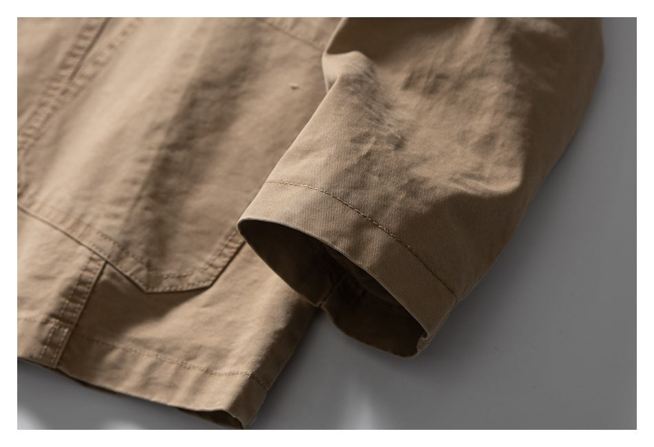 Close-up of the tan jacket sleeve cuff beside the lower edge of a front pocket.