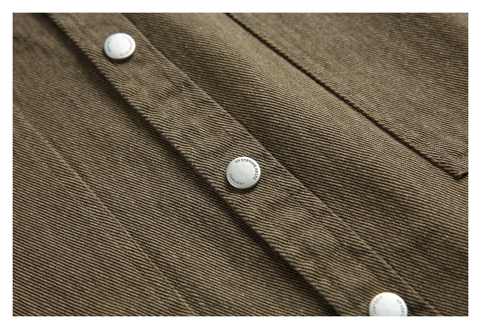 Close-up of silver snap buttons and stitched seams on the brown-olive jacket fabric.
