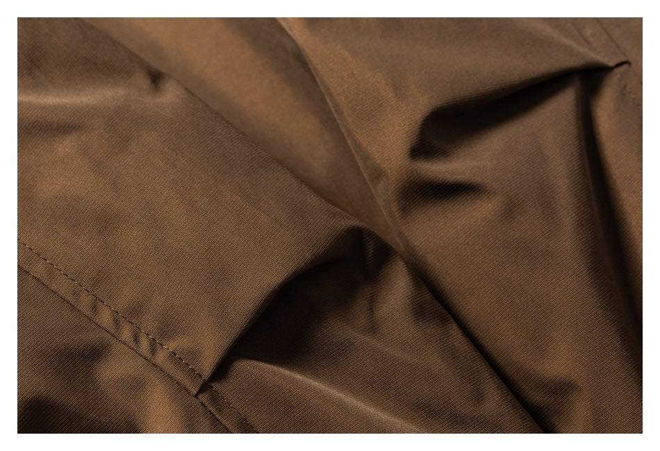 Close-up of brown garment fabric folds and a stitched seam.