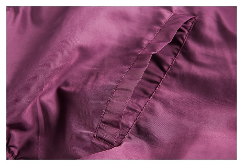 Close-up of a plum jacket showing a narrow welt pocket with a folded flap.