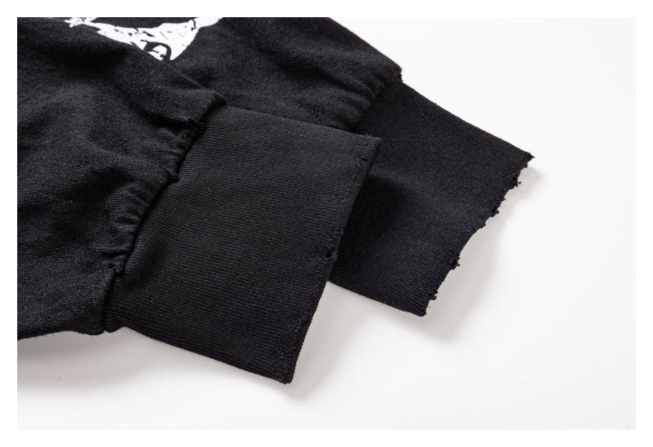 Close-up of a black garment sleeve cuff with a folded ribbed band and raw edge.