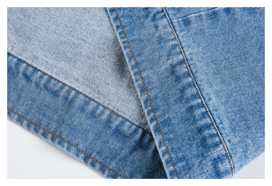 Close-up of overlapping blue denim panels with contrasting brown stitching.