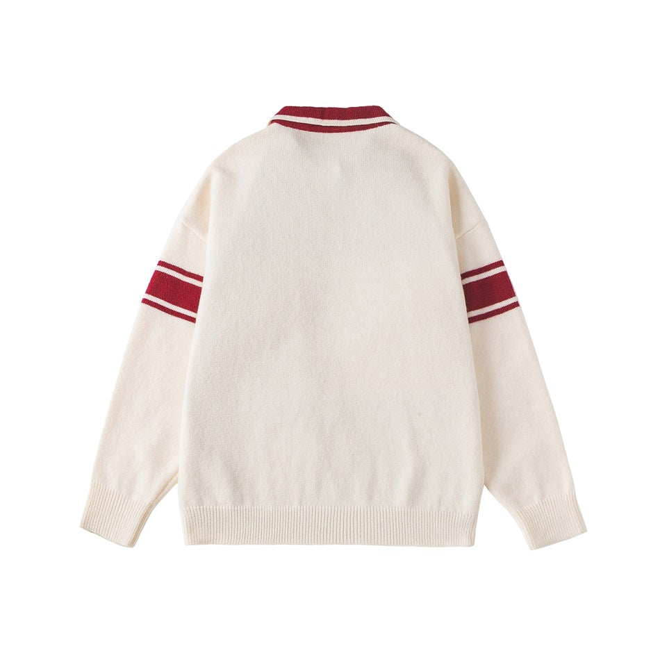 Back view of an ivory sweater with burgundy stripes on the collar and sleeves and ribbed cuffs and hem.