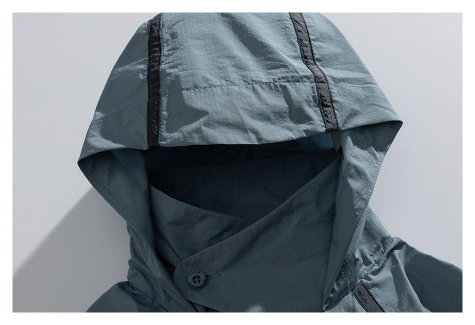 Close-up of a blue-gray hood with dark accent strips and a buttoned front closure.