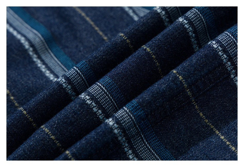 Macro view of dark blue striped fabric, showing blue, white, and fine yellow woven lines.