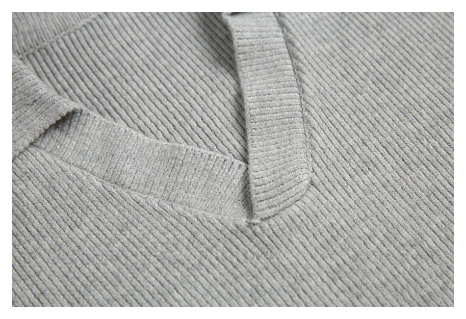 Close-up of a light gray ribbed knit garment showing a seam and folded edge.