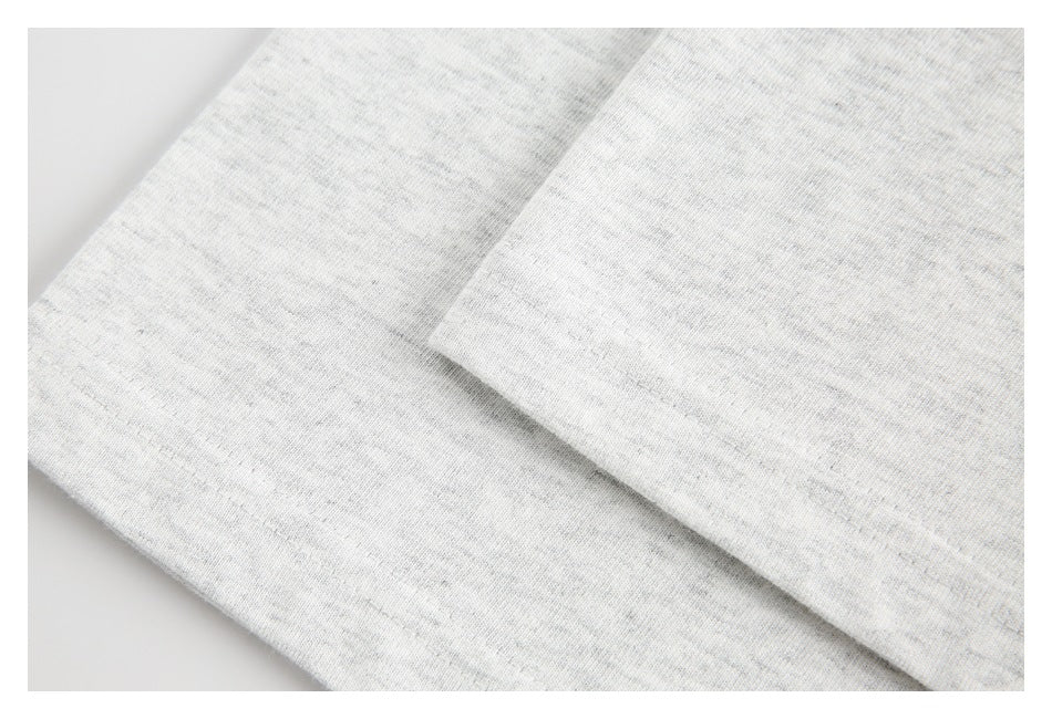 Close-up of the stitched hem on light gray fabric.
