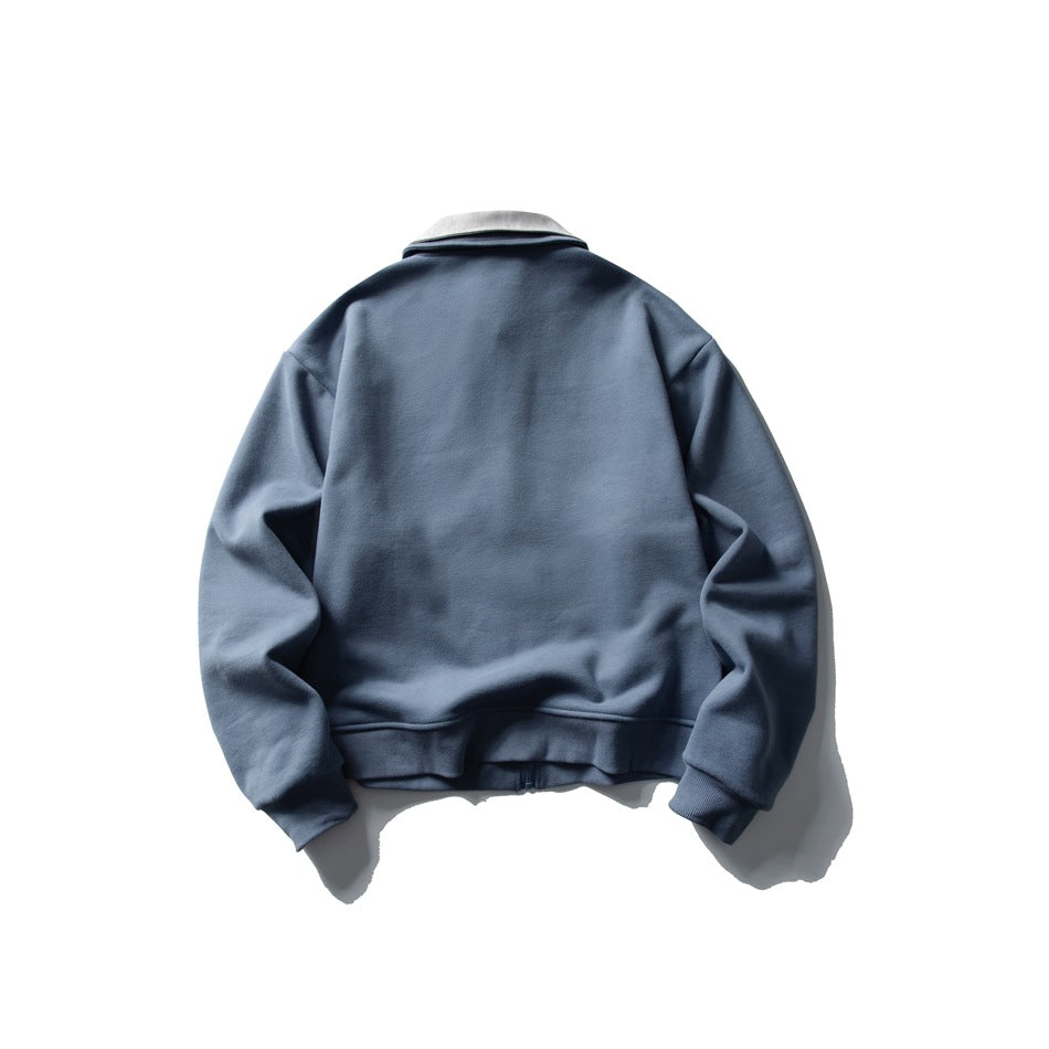 Back view of a blue zip-up jacket with a light gray collar and ribbed cuffs and hem.