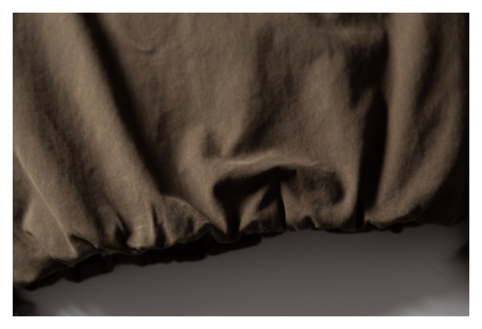 Close-up of the gathered elastic hem on a brown garment.