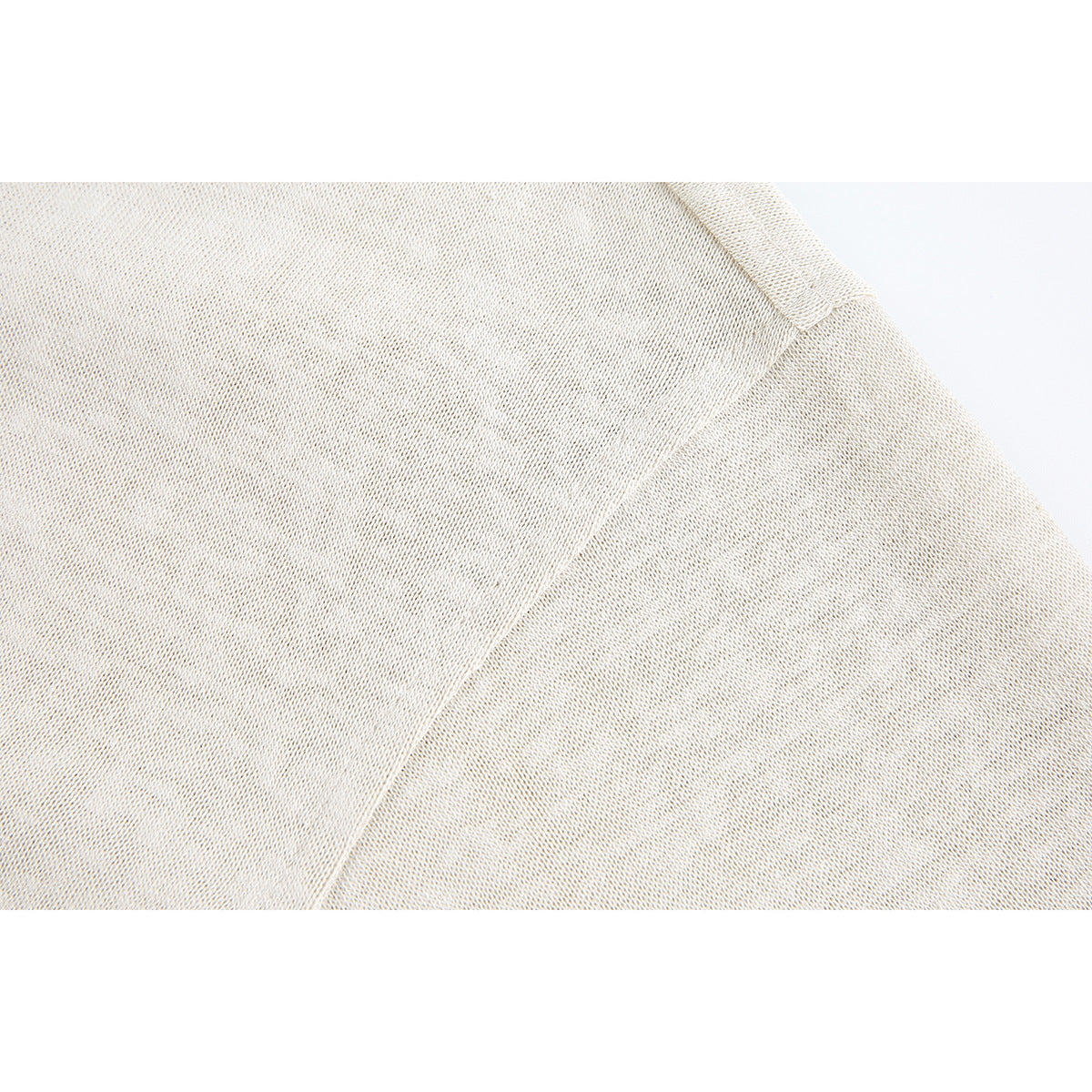 Close-up of the light cream fabric and a curved stitched seam.