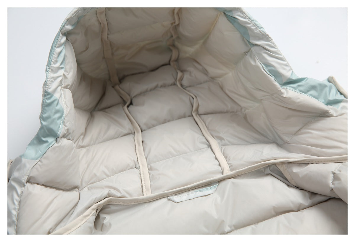 View inside the pale gray quilted jacket, showing its padded lining, interior seams, and pale aqua trim.