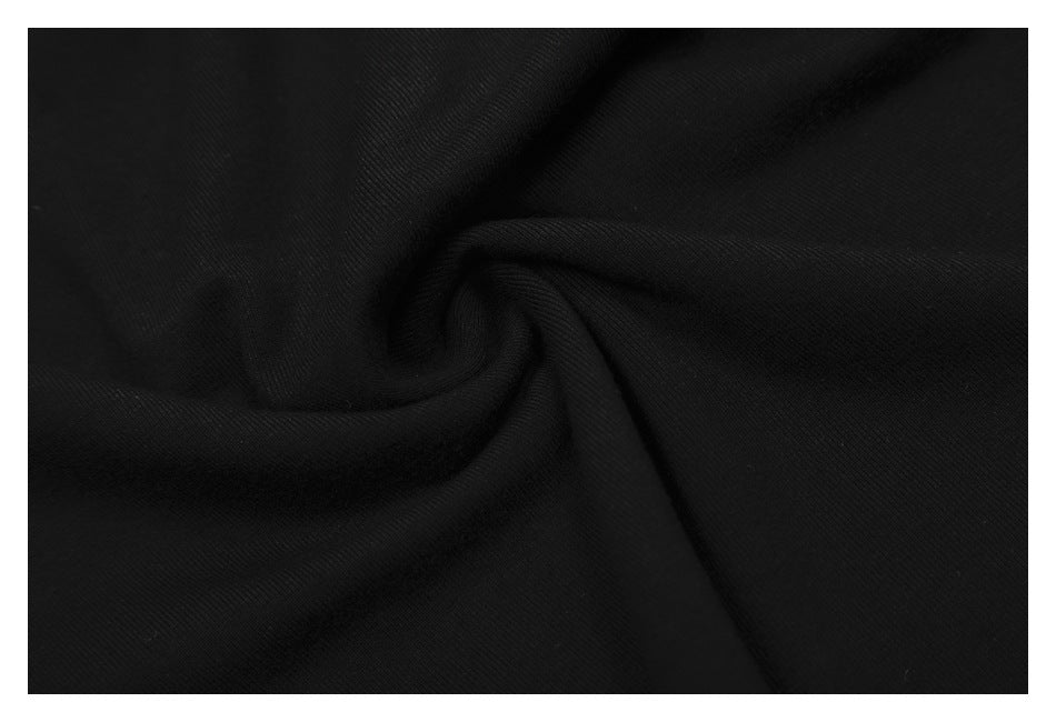 Close-up of black fabric gathered into folds, showing its surface texture.