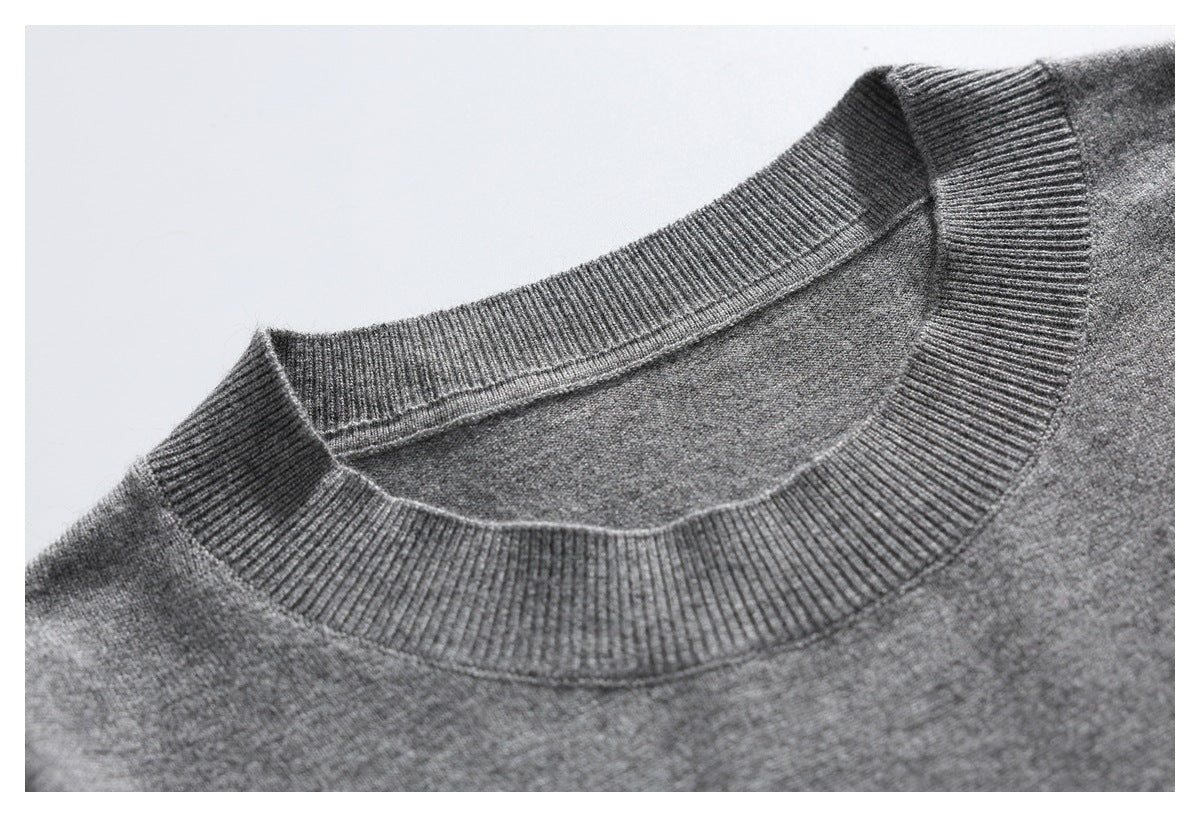 Close-up of a gray knit sweater's wide ribbed crew neckline.