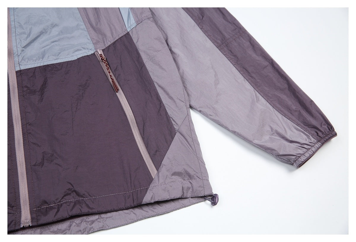 Close-up of the jacket's lower front zipper pocket, color-block panels, sleeve cuff, and hem drawcord.